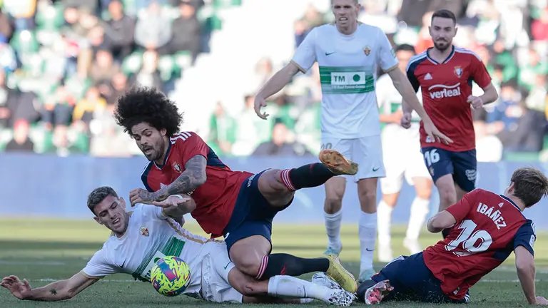El centrocampista del Elche Rául Guti (i) pelea una posesión con el defensa del Osasuna Aridane durante un encuentro correspondiente a la jornada 18 de LaLiga Santander entre el Elche y el Osasuna en el estadio Manuel Martínez Valero en Elche, Alicante, este domingo. EFE/ Ana Escobar