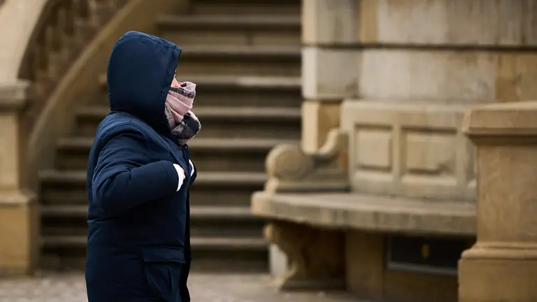 Una persona camina por las calles de Pamplona durante una mañana de frío. PABLO LASAOSA