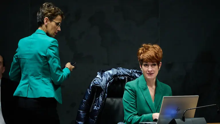 La presidenta del Gobierno, María Chivite, pasa junto a la parlamentaria de EH Bildu, Bakartxo Ruiz durante la celebración del pleno. PABLO LASAOSA