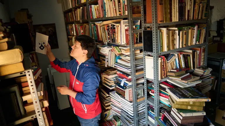 Un hombre busca libros en una de las librerías de Urroz Villa. PABLO LASAOSA