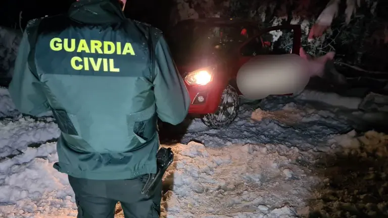 Un agente de la Guardia Civil junto a uno de los turismos rescatados en el alto de El Perdón. GUARDIA CIVIL
