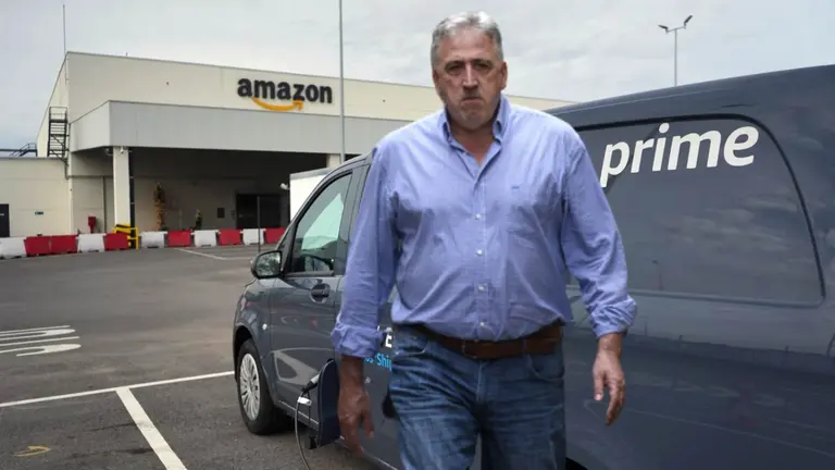 Joseba Asiron en un fotomontaje sobre el fondo de un centro logístico de Amazon.