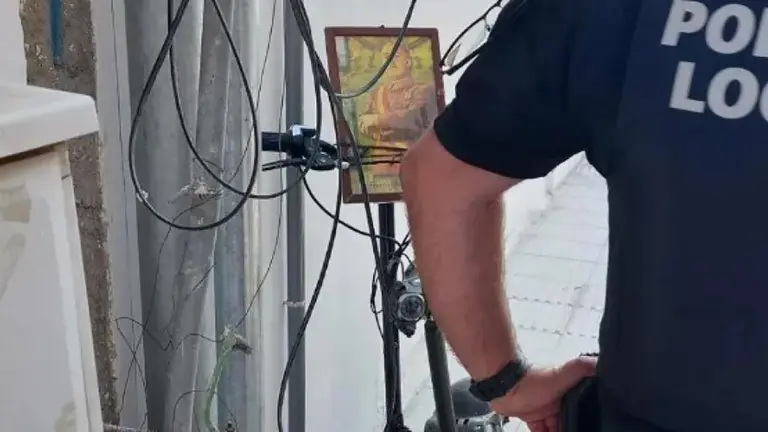 Un agente de la Policía Local de Adra junto al patinete con una foto de Franco. PSOE ADRA