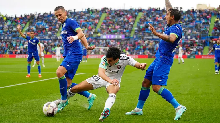 El defensa de Osasuna, Manu Sánchez (c), disputa el balón ante el centrocampista serbio del Getafe, Nemanja Maksimovic (i), durante el encuentro correspondiente a la jornada 37 de Primera División que disputan hoy domingo en el Coliseum Alfonso Pérez de Getafe. EFE / Borja Sánchez-Trillo.