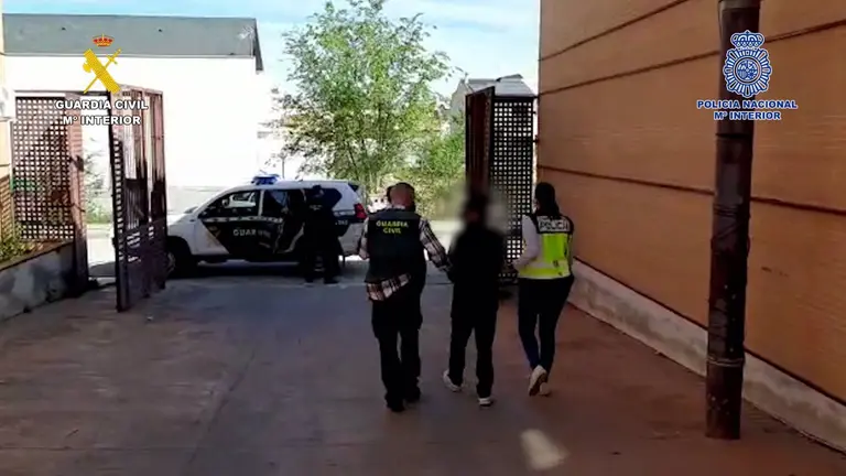 Agentes de la Guardia Civil y la Policía Nacional se llevan a uno de los detenidos. GUARDIA CIVIL
