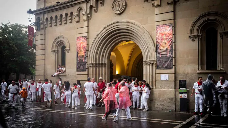Varias personas se resguardan de la lluvia en el primer día de los San Fermines 2023 en Pamplona. JASMINA AHMETSPAHIC