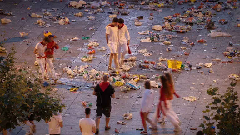 GRAFCAV635. PAMPLONA, 08/07/2023.- Los más trasnochadores deambulan por la Plaza del Castillo de Pamplona entre la basura acumulada tras la primera noche del fin de semana de los Sanfermines 2022 antes del encierro de este sábado. EFE/ Villar López
