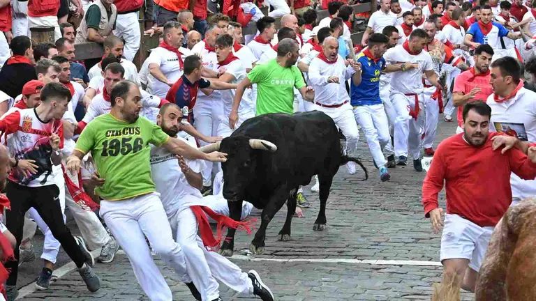 Los mozos se apartan al paso de uno de uno de los toros y un cabestro de la ganadería extremeña Jandilla, durante el sexto encierro de Sanfermines, este miércoles, en Pamplona. EFE/Daniel Fernández