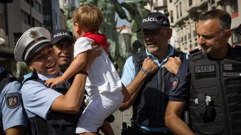 Niños y niñas se fotografían con el grupo de agentes de la policía de otros países europeos que han llegado a Pamplona para colaborar con la Policía Nacional durante las fiestas y en su charla con EFE explican en que consiste su labor estos días de San Fermín. Pasean por la ciudad aportando información a quien no habla castellano y ayudar a la policía española con las atenciones con ciudadanos internacionales. EFE/ Villar López