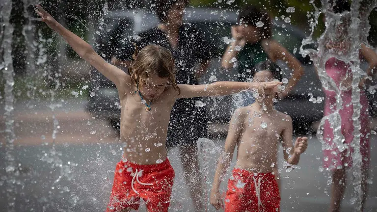 Varios niños se divierten a la vez que se refrescan en una fuente de Pamplona en una jornada en la que el cielo estará este martes en Navarra poco nuboso o despejado aumentando la nubosidad por la tarde, sobre todo en el tercio norte, y con nubosidad de evolución diurna, con un aumento notable de las temperaturas máximas, que podrían superar los 40 grados en el sur. EFE/ Villar López