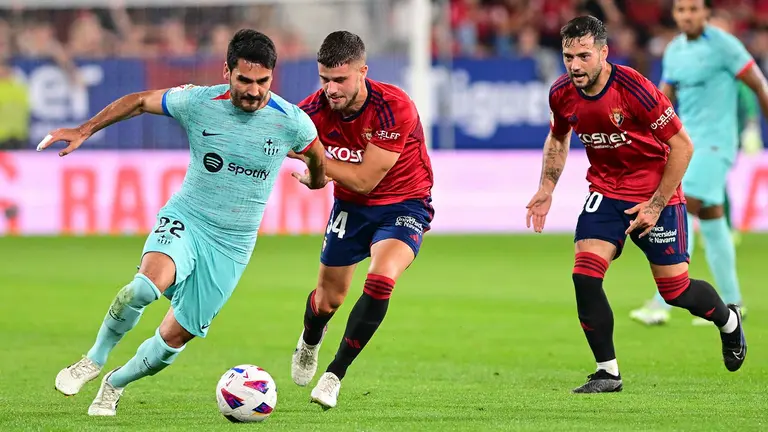 PAMPLONA, 03/09/2023.- El centrocampista alemán del FC Barcelona, Ilkay Gündogan (i) disputa una posesión ante Iker Muñoz (c) centrocampista de Osasuna durante el encuentro correspondiente a la cuarta jornada de primera división que disputan hoy domingo frente a Osasuna en el estadio de El Sadar, en Pamplona. EFE/ Inaki Porto
