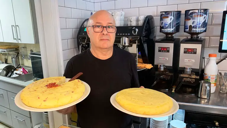 Pedro jesús Sanz sostiene dos tortillas de patata en la taberna Albéniz de Pamplona. Navarra.com