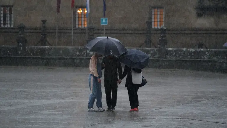 Varias personas se resguardan bajo un paraguas de la lluvia, el viento y el mal tiempo. ÁLVARO BALLESTEROS / EUROPA PRESS