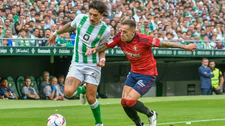 El defensa del Real Betis Héctor Belleín (i) disputa una posesión ante Rubén Peña, defensa de Osasuna, durante el partido de la jornada 11 de LaLiga EA Sports, este domingo en el estadio Benito Villamarín de Sevilla. EFE/ Raúl Caro.