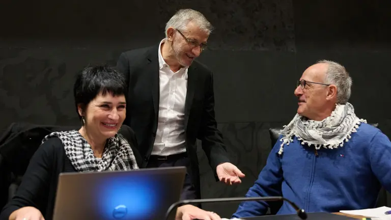 la parlamentaria de Bildu Laura Aznal (i) y Adolfo Araiz (d) hablan con el Vicepresidente primero y consejero de Presidencia e Igualdad del Gobierno de Navarra Félix Taberna (c) este jueves durante el Pleno del Parlamento de Navarra en el que se han debatido mociones sobre la política comercial común europea, una prueba única de la EBAU en España o la guerra en la franja de Gaza, y al que los parlamentarios de los grupos EH Bildu y Contigo Navarra-Zurekin Nafarroa han acudido al pleno con el pañuelo palestino o kufiya. EFE/Iñaki Porto