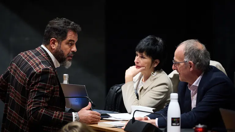 El socialista Ramón Alzórriz habla con Laura Aznal y Adolfo Araiz de EH Bildu durante la celebración del pleno. PABLO LASAOSA