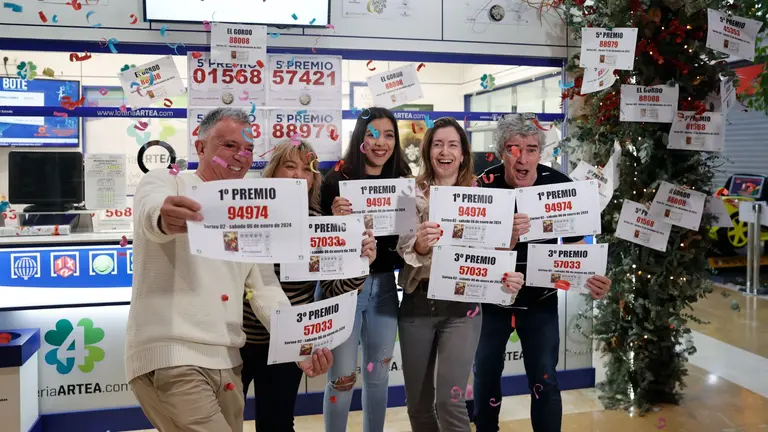 Los loteros de la administración de lotería del centro comercial de Artea, en el municipio de Leioa, celebran este sábado tras vender décimos de los números agraciados con el primer y tercer premio del Sorteo Extraordinario de Lotería Nacional de El Niño. EFE/ Luis Tejido
