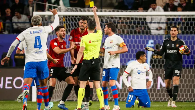 El árbitro Muñiz Ruiz (c) muestra la tarjeta amarilla a Alejandro Catena (3-i), de Osasuna, durante la segunda semifinal de la Supercopa de España que FC Barcelona y CA Osasuna disputan este jueves en el estadio Al-Awwal Park de Riad, en Arabia Saudí. EFE/Juan Carlos Cárdenas