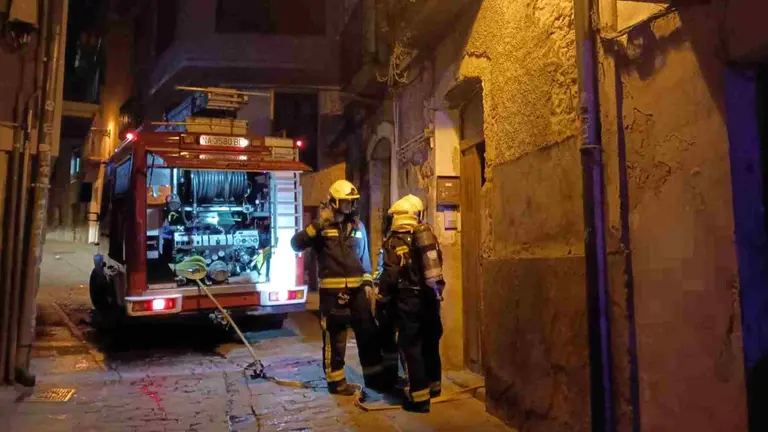Una dotación de bomberos en la puerta del edificio siniestrado. BOMBEROS DE NAVARRA