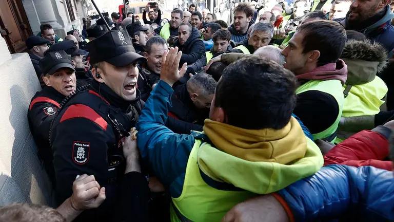 GRAFCAV9765. PAMPLONA, 07/03/2024.- Un grupo de agricultores ha tratado de acceder al interior del Parlamento de Navarra, lo que les ha sido impedido por la Policía Foral, en el momento en el que intervenía el portavoz socialista después de que se supiera que la Cámara no había admitido a trámite una enmienda de UPN que recogía sus demandas.EFE/ Jesus Diges