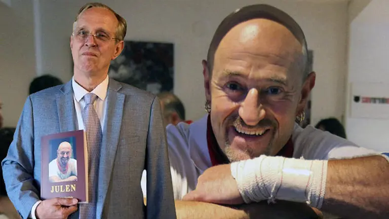 Emmanuel de Marichalar con un ejemplar del libro sobre Julen Madina sobre una fotografía del corredor del encierro de Pamplona.