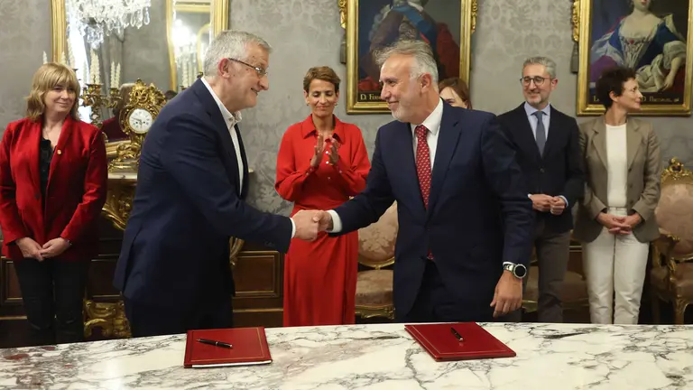 El vicepresidente primero y consejero de Presidencia e Igualdad, Félix Taberna, y el ministro de Política Territorial y Memoria Democrática, Ángel Victor Torres, firman el acuerdo, con María Chivite detrás. GOBIERNO DE NAVARRA