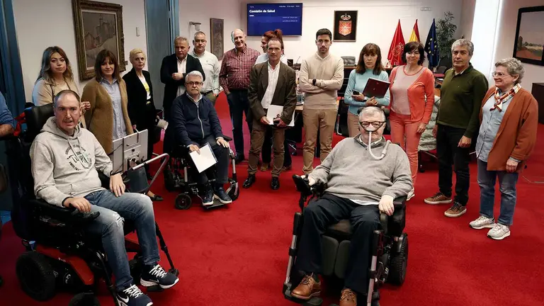 Representantes de la Asociación Navarra de Esclerosis Lateral Amiotrófica (ANELA) junto a varios parlamentarios, exponen este miércoles en el Parlamento de Navarra ante la comisión correspondiente la situación en la que se encuentran.  EFE/ Jesús Diges