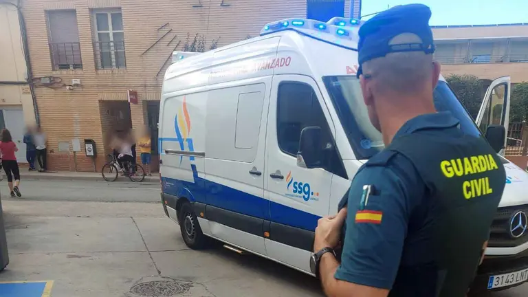 Un agente de la Guardia Civil ante la ambulancia que evacuó a uno de los heridos en la pelea. GUARDIA CIVIL