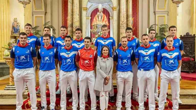 Los pelotaris de Aspe y Baiko posan con pañuelos de San Fermín delante del patrón de Navarra. Foto Caixabank.