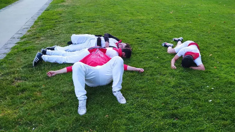 Un grupo de amigos duermen sobre el césped de la Ciudadela de Pamplona tras una larga noche de San Fermín. SERGIO DURÁN