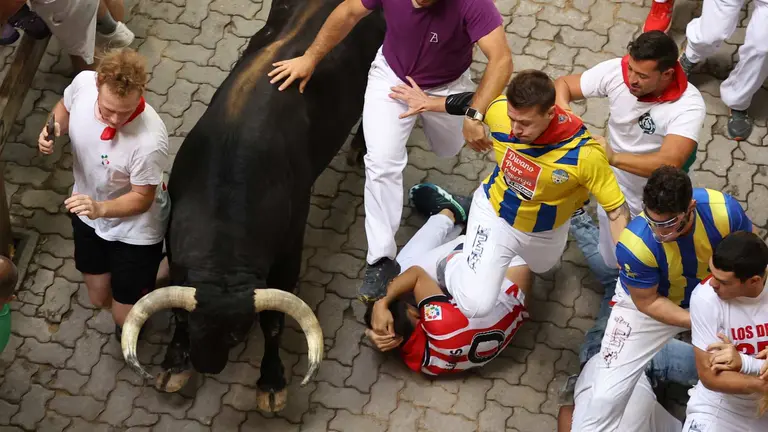 Los mozos son perseguidos por toros de la ganadería gaditana de Fuente Ymbro este miércoles durante el cuatro encierro de los Sanfermines, en Pamplona. EFEJ. P. Urdioz