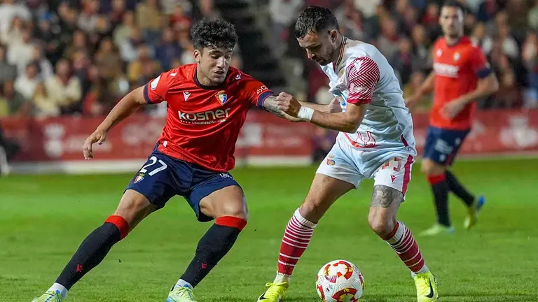 El jugador del Chiclana CF Mawi (d) disputa un balón ante el centrocampista del Osasuna Iker benito este martes, durante el partido de primera ronda de Copa del Rey, entre el Chiclana CF y el Club Atlético Osasuna, en el Campo Municipal de Chiclana (Cádiz). EFE/ Román Ríos