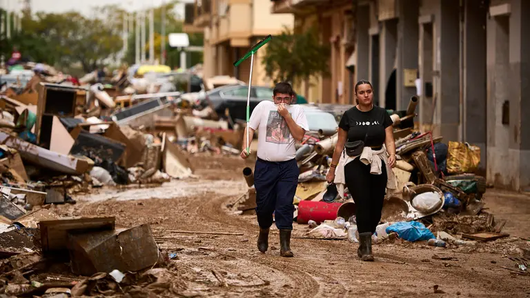Dos vecinos caminan por la calle en Paiporta. PABLO LASAOSA