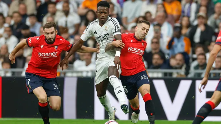 El delantero brasileño del Real Madrid Vinicius Jr, y el delantero de Osasuna Rubén Peña, durante el partido de la jornada 13 de LaLiga entre Real Madrid y Osasuna, este sábado en el estadio Santiago Bernabéu en Madrid.-EFE/ Daniel González
