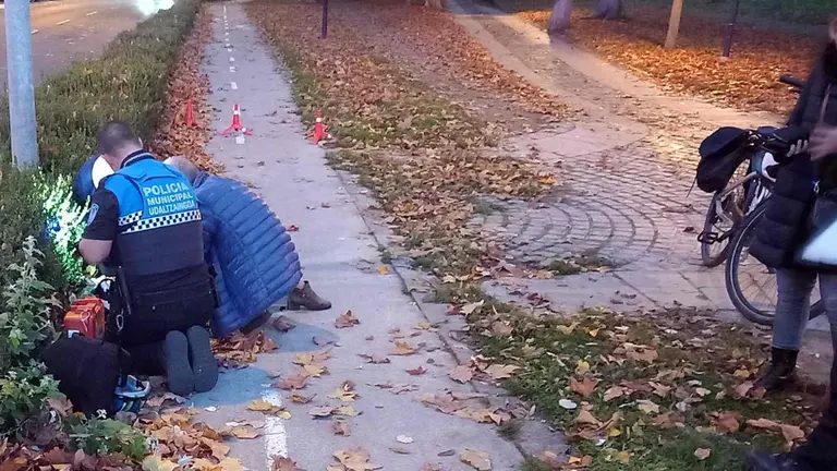 Un agente de la Policía Municipal de Pamplona atiende a la mujer herida en el carril bici de Pamplona. POLICÍA MUNICIPAL DE PAMPLONA