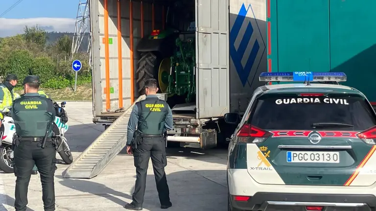 Agentes de la Guardia Civil de Navarra ante el camión que transportaba los tractores robados. GUARDIA CIVIL