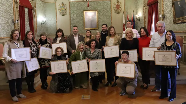 Fotografía de grupo de los profesores jubilados homenajeados junto a los concejales y el alcalde de Tudela. AYUNTAMIENTO DE TUDELA
