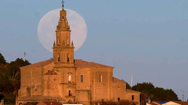 La primera luna llena del invierno, llamada también la luna del lobo sale detrás de la Iglesia de San Miguel en la localidad navarra de Larraga. EFE/Iñaki Porto