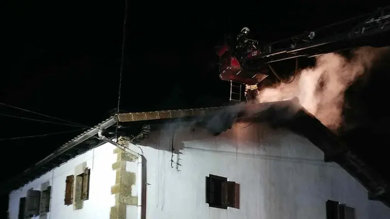 Un bombero sobre la grúa extinguiendo el incendio del tejado de una casa en Zandio. BOMBEROS DE NAVARRA