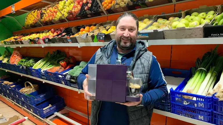 Aitor López sostiene la cafetera portátil en la frutería Marian de Pamplona. Navarra.com