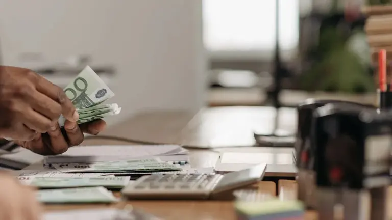 Contando billetes de 100 euros en un banco. CEDIDA