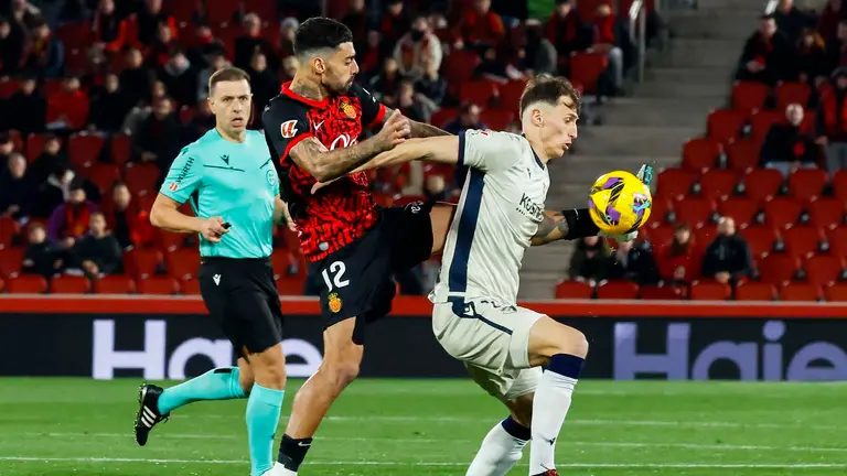 El centrocampista portugués del Mallorca Samuel Costa (i) pelea un balón con el delantero croata de Osasuna Ante Budimir en el partido de LaLiga entre el Mallorca y el Osasuna, este lunes en el estadio de Son Moix, en Palma. EFE/CATI CLADERA