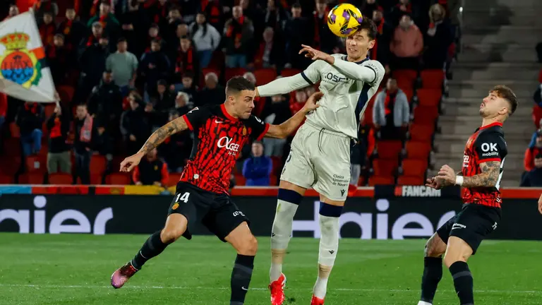 El centrocampista del Mallorca Dani Rodríguez (i) pelea un balón con el centrocampista de Osasuna Lucas Torró en el partido de LaLiga entre el Mallorca y el Osasuna, este lunes en el estadio de Son Moix, en Palma. EFE/CATI CLADERA