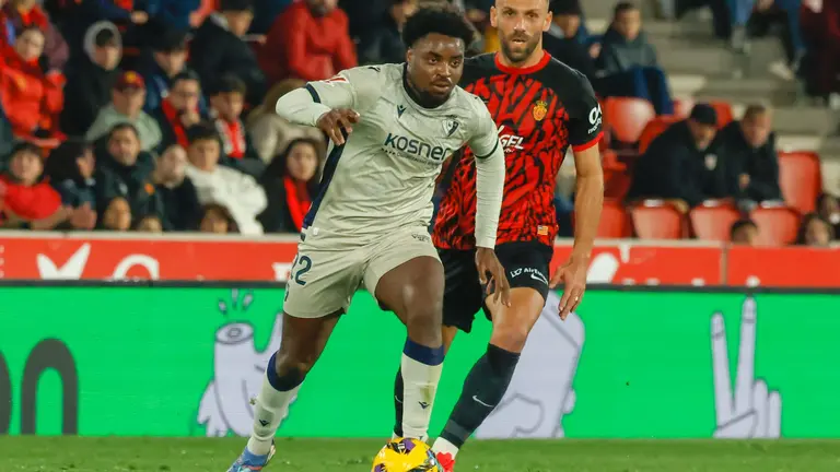El defensa de Osasuna Enzo Boyomo (i) juega un balón ante Vedat Muriqi, de Osasuna, durante el partido de LaLiga de fútbol que RCD Mallorca y CA Osasuna disputan este lunes en el estadio de Son Moix, en Palma. EFE/Cati Cladera