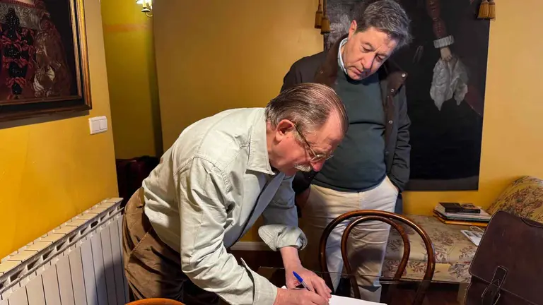 Alfonso Galbis, firmando la ILP, junto a Manuel Sierra, representantes de 'Navarros todos y la historia completa'.