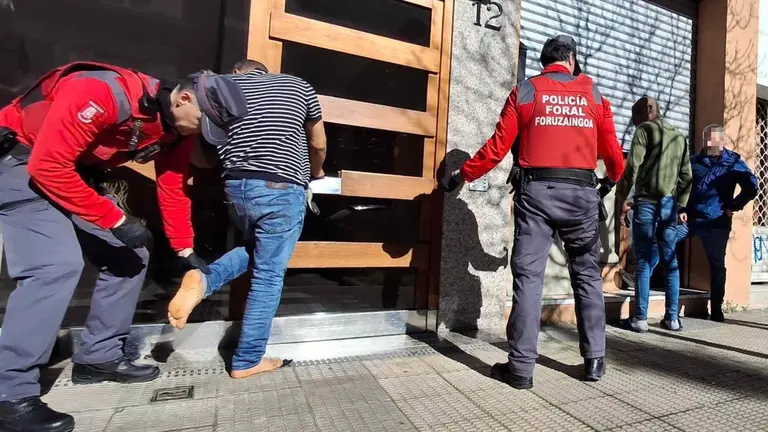 Agentes de la policía Fora, de uniforme y de paisano, durante el registro de una bajera 'okupada' y la detención de un hombre en Pamplona. POLICÍA FORAL