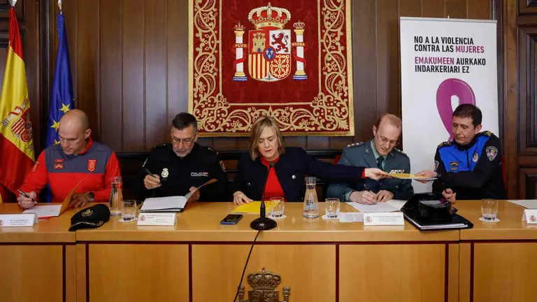 La delegada del Gobierno en Navarra, Alicia Echeverría (c), y representantes de los cuatro cuerpos policiales que actúan en Pamplona durante la firma este lunes del protocolo de colaboración para la atención policial a víctimas de violencia de género en la capital navarra. EFE/ Villar López
