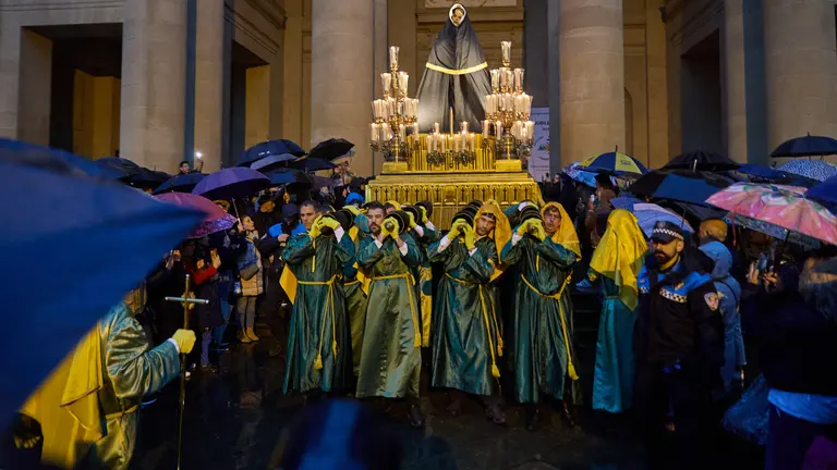 Retorno del paso de La Dolorosa desde la Catedral de Pamplona hasta la iglesia de San Lorenzo tras la suspensión de la procesión de Viernes Santo debido a la lluvia y que ha obligado a cubrir la imagen con un impermeable de 'Goretex'. IÑIGO ALZUGARAY
