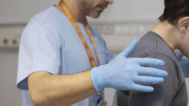 El fisioterapeuta Fabio Jiménez trabaja con un menor en tratamiento con protonterapia en la Clínica Universidad de Navarra.  CLÍNICA UNIVERSIDAD DE NAVARRA