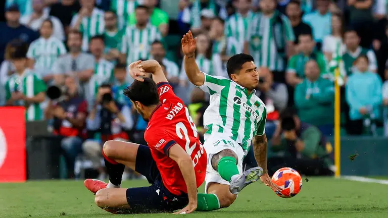 SEVILLA, 11/05/2025.- El delantero colombiano del Betis, Cucho Hernández (d), disputa el balón ante el defensa de Osasuna, Alejandro Catena, durante el encuentro correspondiente a la jornada 35 de LaLiga EA Sports que disputan hoy domingo Betis y Osasuna en el estadio Benito Villamarín, en Sevilla. EFE / Julio Muñoz.